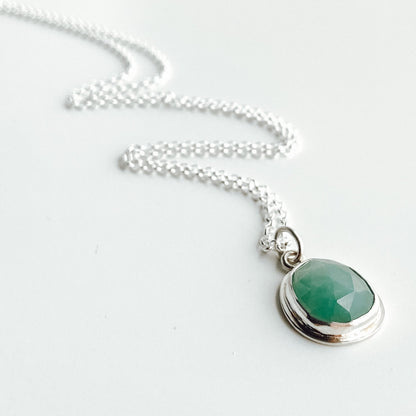 Aqua green rose-cut gandiderite pendant displayed diagonally on a white background