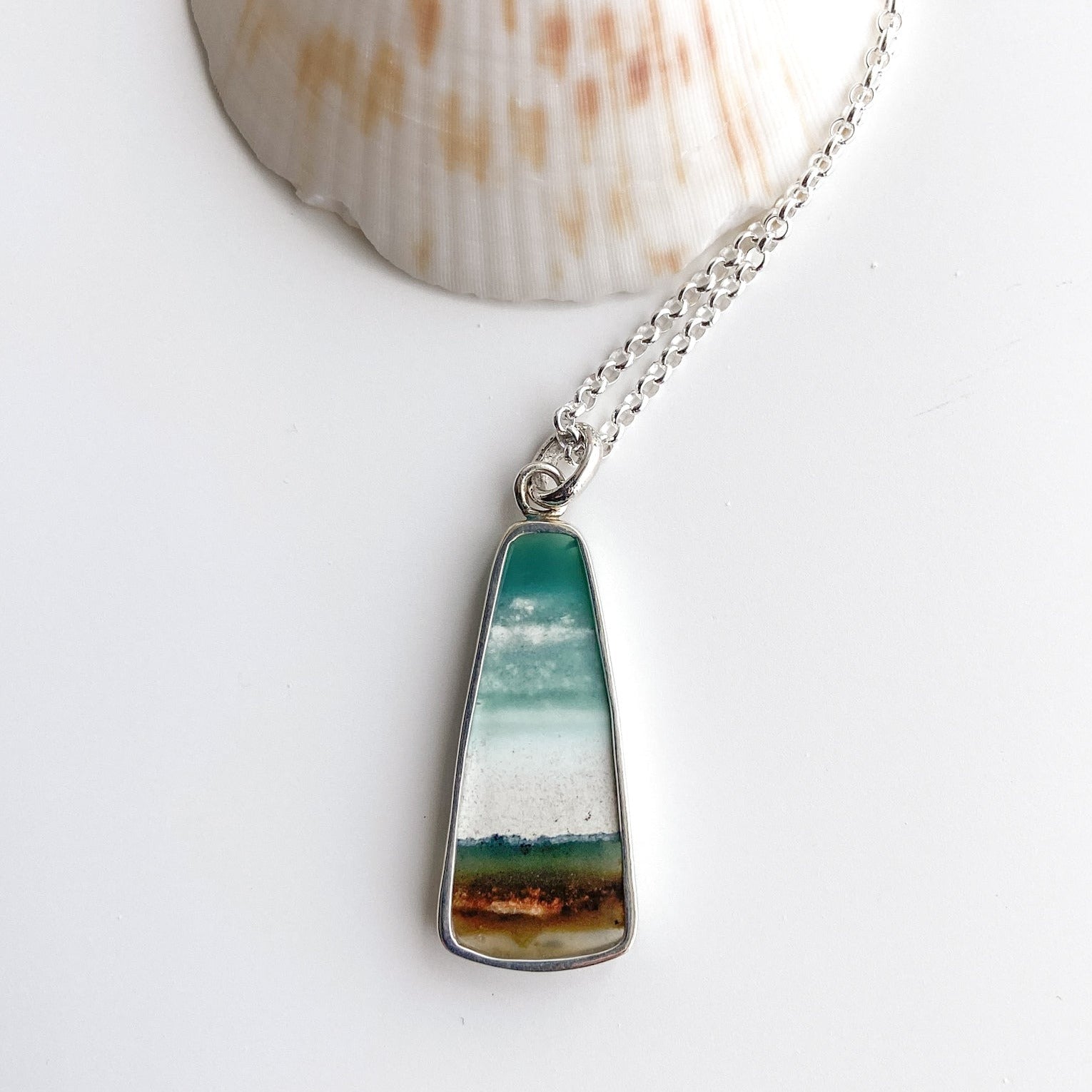 The backside of the opalized wood pendant is cut out to reveal the polished stone.