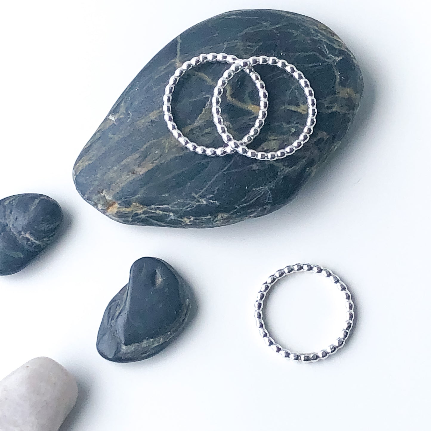sterling silver beaded stacking rings on a rock